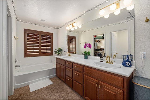 bathroom with double vanity, a bath, and a sink