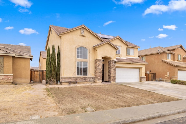 view of front of home featuring an attached garage, roof mounted solar panels, stucco siding, stone siding, and driveway