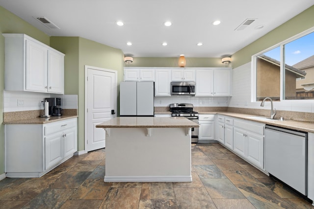 kitchen with a sink, visible vents, appliances with stainless steel finishes, and white cabinets