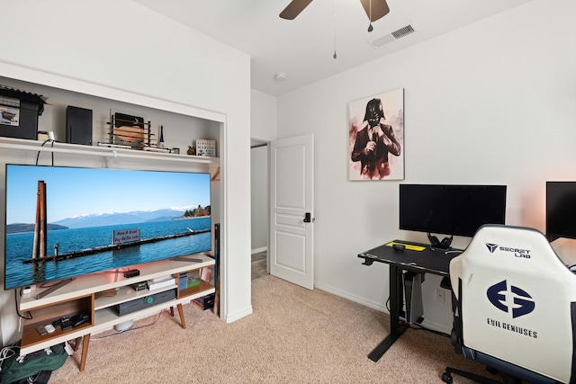 carpeted office featuring visible vents, baseboards, and a ceiling fan