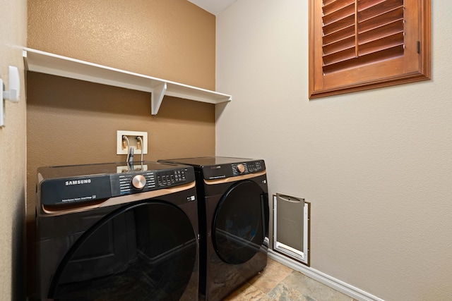 clothes washing area featuring baseboards, washing machine and dryer, and laundry area