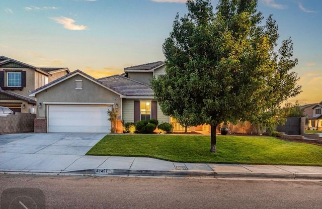 view of front of house with an attached garage, brick siding, concrete driveway, stucco siding, and a front lawn