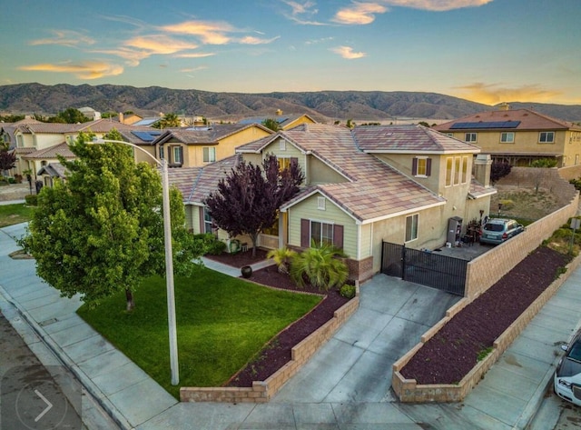 view of front facade featuring a mountain view, concrete driveway, and a residential view