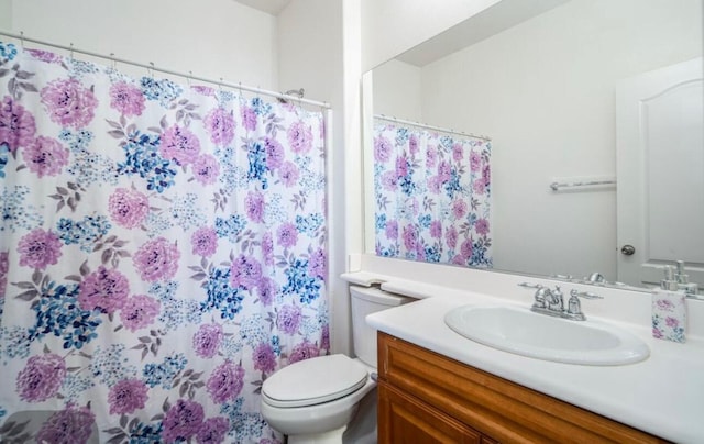 bathroom featuring toilet, curtained shower, and vanity