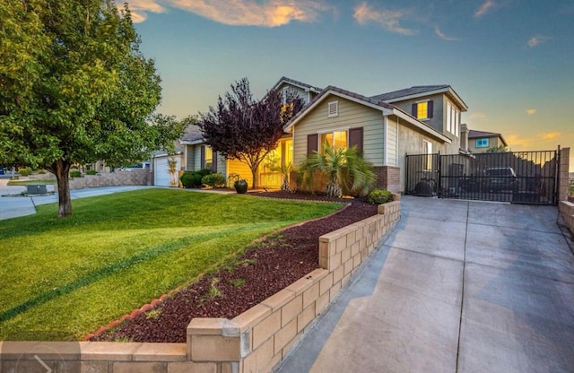 view of front of house featuring driveway, a gate, a front lawn, and brick siding