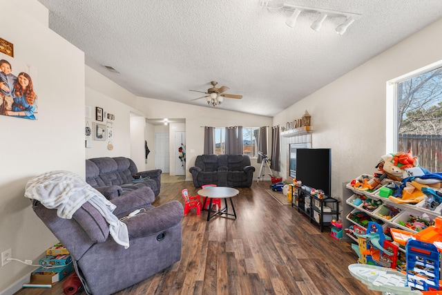 living room with ceiling fan, a wealth of natural light, wood finished floors, and vaulted ceiling