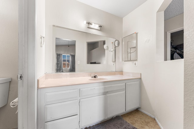 bathroom with baseboards, vanity, and tile patterned flooring