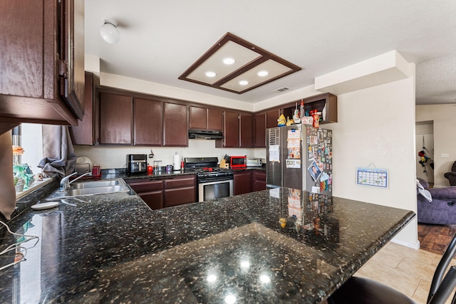 kitchen with visible vents, a sink, under cabinet range hood, stainless steel appliances, and a peninsula