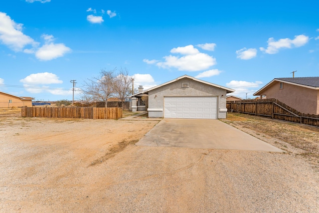 exterior space featuring stucco siding, concrete driveway, a garage, and fence