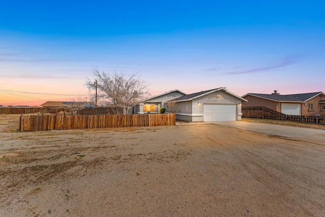 view of front of property featuring an attached garage, fence, driveway, and stucco siding