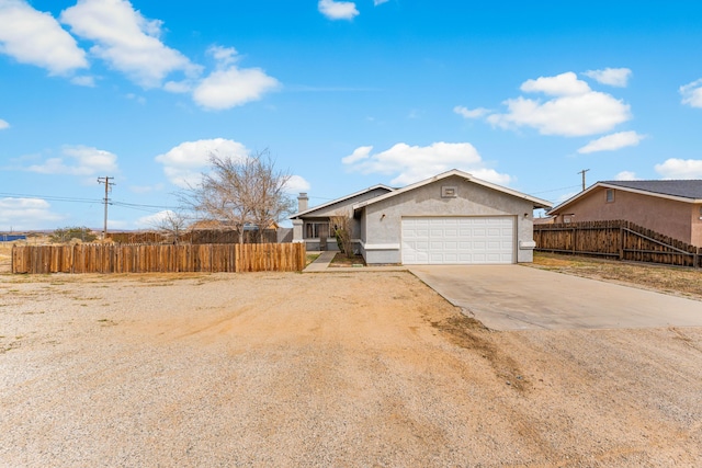 ranch-style house with concrete driveway, fence, a garage, and stucco siding