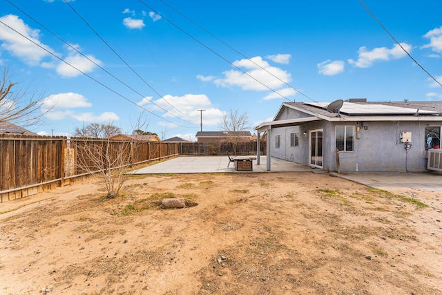 view of yard featuring a fenced backyard, central AC, and a patio