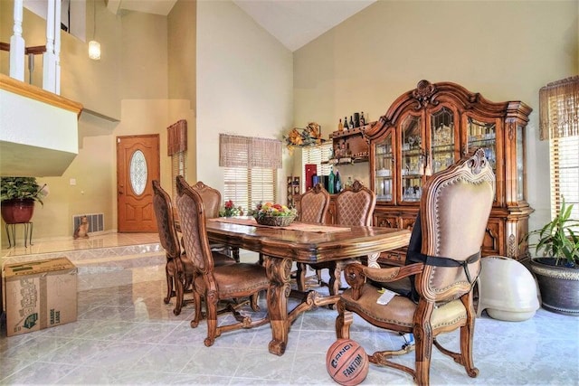 dining room with high vaulted ceiling