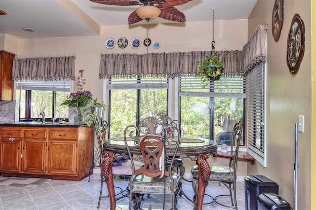 dining room with ceiling fan, sink, and a healthy amount of sunlight