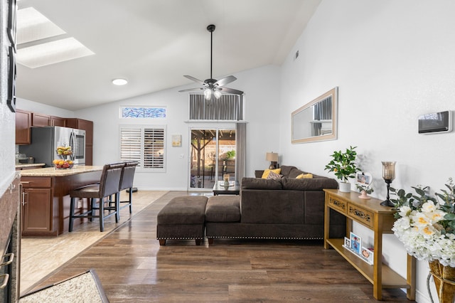 living room featuring ceiling fan, dark wood-type flooring, and lofted ceiling