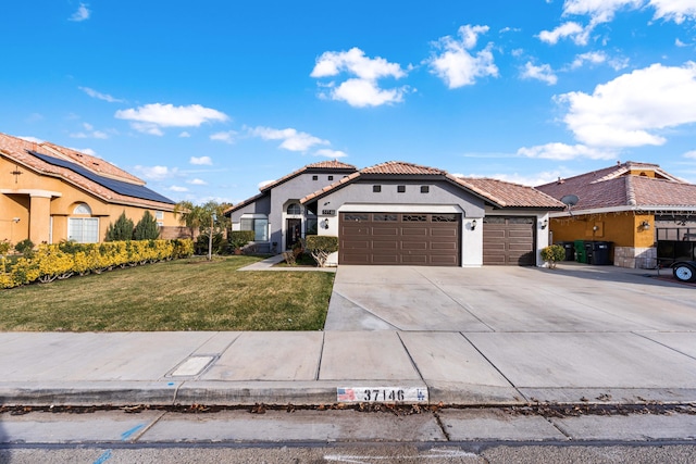 mediterranean / spanish home with a front yard and a garage