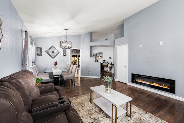 living room featuring plenty of natural light, lofted ceiling, dark hardwood / wood-style floors, and a notable chandelier