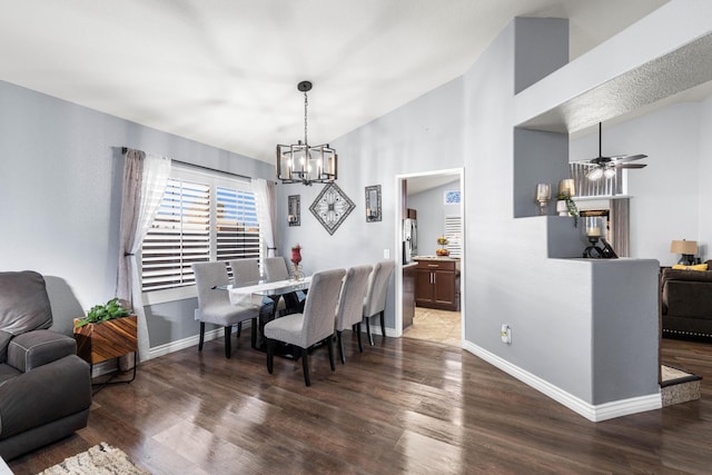 dining area with ceiling fan with notable chandelier, dark hardwood / wood-style flooring, and lofted ceiling