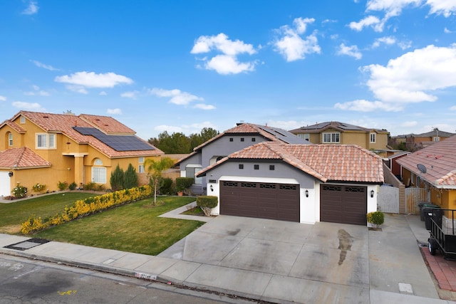 mediterranean / spanish-style house with a front lawn, solar panels, and a garage