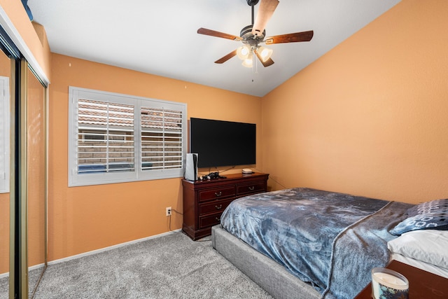 carpeted bedroom with ceiling fan, a closet, and lofted ceiling