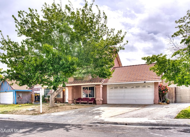 37214 Bunker Ct, Palmdale, CA 93550 - view of front facade with a tiled roof, a garage, driveway, and stucco siding