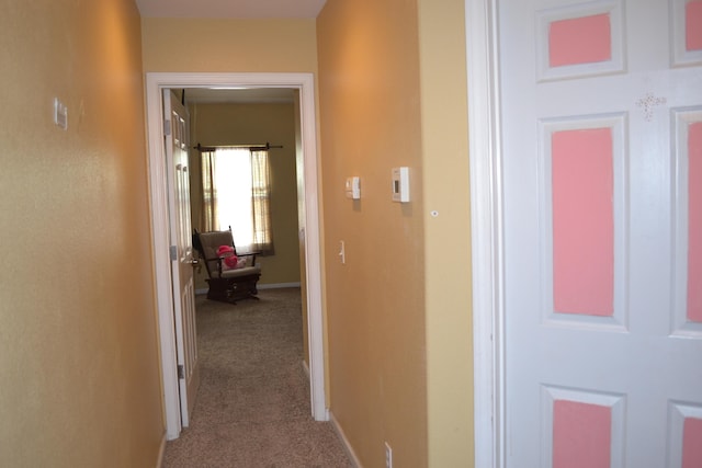 hallway with baseboards and carpet flooring