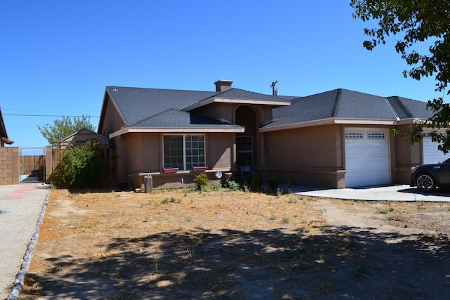 ranch-style home featuring a chimney, fence, an attached garage, stucco siding, and a gate