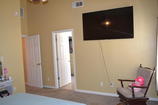 carpeted bedroom featuring a towering ceiling, baseboards, and visible vents