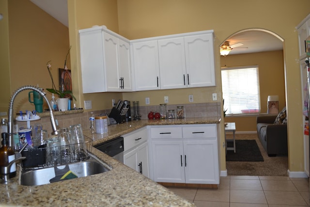 kitchen featuring light tile patterned floors, light stone counters, ceiling fan, a sink, and white cabinets