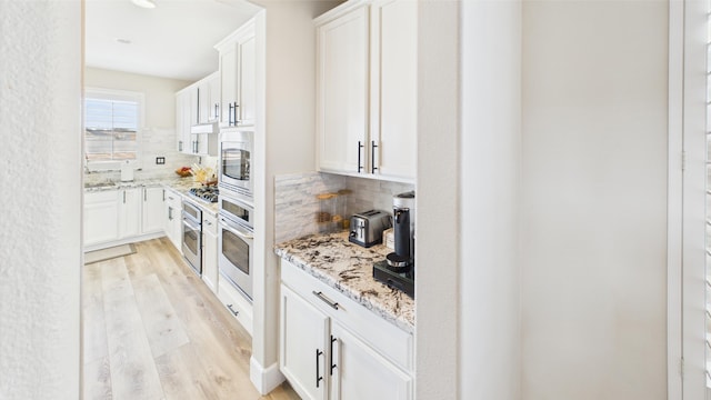 3929 Derby Cir, Quartz Hill, CA 93536 - kitchen featuring stainless steel appliances, tasteful backsplash, light wood-type flooring, and white cabinetry