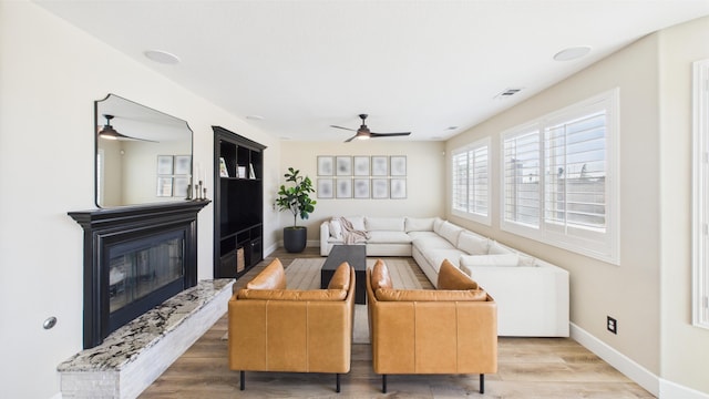 3929 Derby Cir, Quartz Hill, CA 93536 - living room featuring ceiling fan, light wood-style flooring, baseboards, and a glass covered fireplace