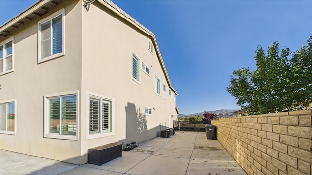 3929 Derby Cir, Quartz Hill, CA 93536 - view of home's exterior featuring stucco siding, a patio area, a fenced backyard, a mountain view, and central air condition unit