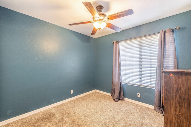 empty room featuring a ceiling fan, baseboards, and carpet floors