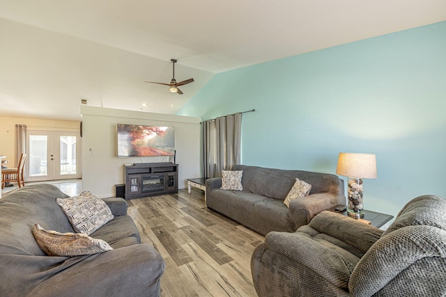 living room featuring lofted ceiling, french doors, light wood finished floors, and ceiling fan