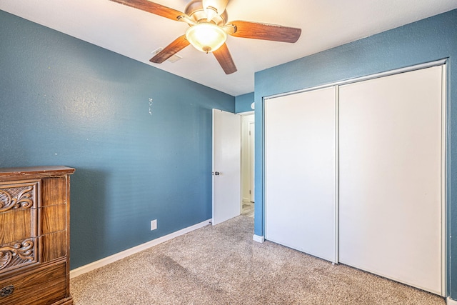 unfurnished bedroom featuring a closet, baseboards, carpet, and ceiling fan