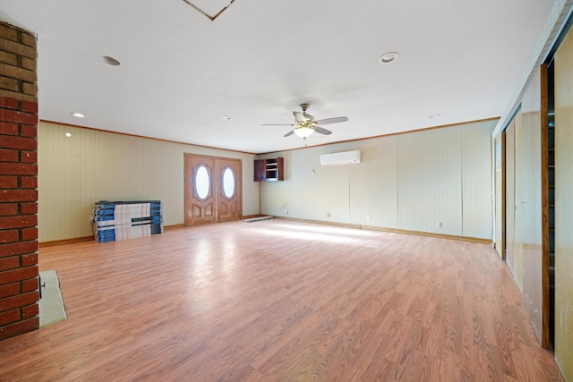 unfurnished living room featuring light hardwood / wood-style floors, a wall mounted AC, crown molding, and ceiling fan