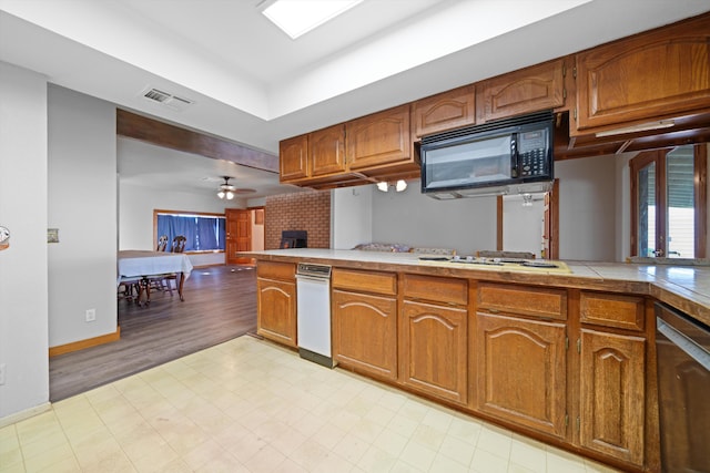 kitchen with kitchen peninsula, a fireplace, white gas stovetop, ceiling fan, and dishwasher