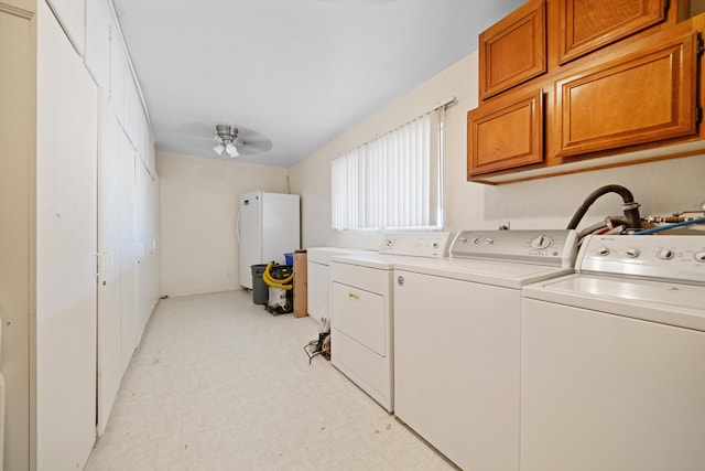 washroom featuring washing machine and dryer, ceiling fan, and cabinets