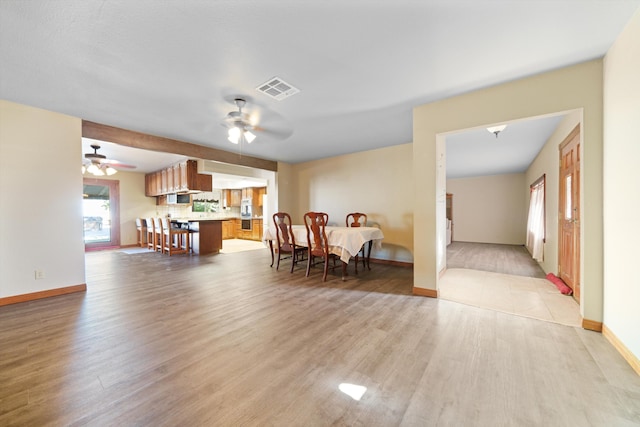 dining area with ceiling fan and light hardwood / wood-style floors