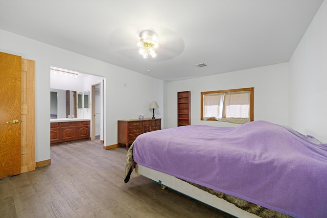 bedroom featuring ceiling fan, connected bathroom, and light hardwood / wood-style flooring