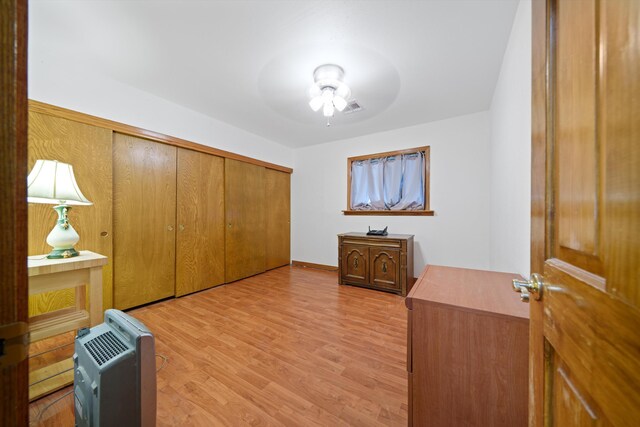 interior space featuring a closet, light hardwood / wood-style floors, heating unit, and ceiling fan