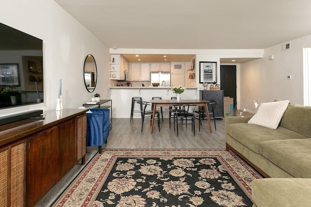 living area with light wood-style flooring and visible vents