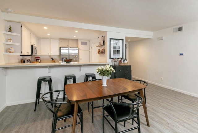 dining area featuring recessed lighting, visible vents, baseboards, and light wood-style flooring