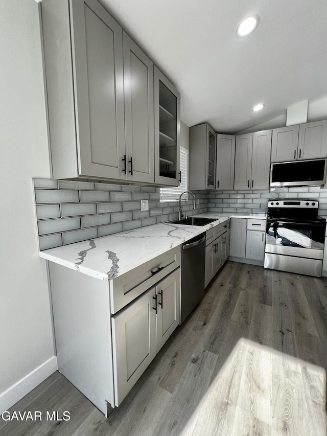 10165 E E Ave Unit S10, Littlerock, CA 93543 - kitchen featuring appliances with stainless steel finishes, gray cabinets, decorative backsplash, light wood-style flooring, and glass insert cabinets