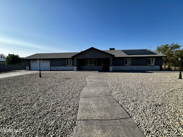10165 E E Ave Unit S10, Littlerock, CA 93543 - single story home with stucco siding, an attached garage, stone siding, solar panels, and concrete driveway