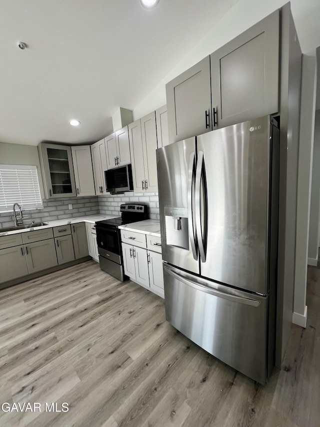 10165 E E Ave Unit S10, Littlerock, CA 93543 - kitchen featuring appliances with stainless steel finishes, gray cabinetry, decorative backsplash, light countertops, and light wood-style floors