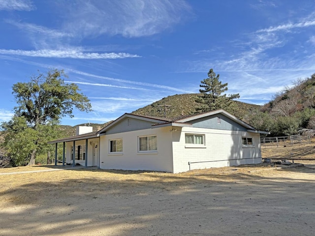 view of side of home with a mountain view and a porch