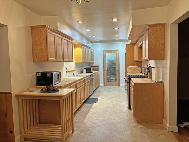 kitchen with light brown cabinets, light tile patterned floors, sink, and appliances with stainless steel finishes