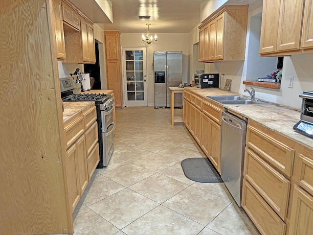 kitchen featuring sink, a chandelier, decorative light fixtures, light brown cabinetry, and appliances with stainless steel finishes