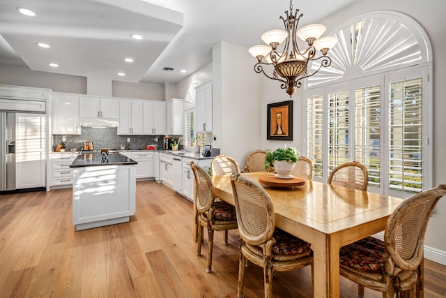 dining area with a chandelier, light hardwood / wood-style floors, and sink